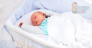 newborn baby sleeping in a bassinet