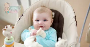 Baby in a compact baby swing having fun